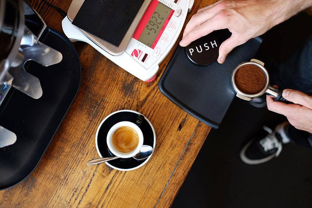 Clockwork Espresso PUSH tamper in cafe use with basket and scales